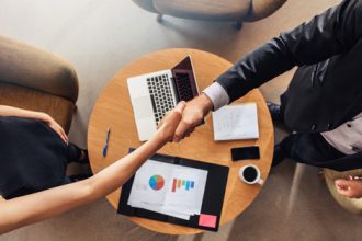 A business meeting shows a handshake signifying agreement in the vet sector.