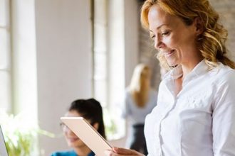 A businesswoman reviews data on a tablet, reflecting changes in the vet sector.