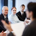 A business meeting shows professionals discussing vet sector updates.