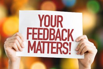 Hands holding a sign emphasizing the importance of learner feedback in VET.