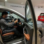 A man examines the interior of an MG Hector at a car dealership, demonstrating reasonable adjustments for learners with.