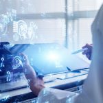 A scientist reviews data analysis with a digital tablet and hologram, showcasing CAQA Labs' virtual training environment.