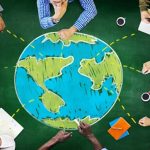 A team brainstorms global strategy using a world map, reflecting discussions around international education.